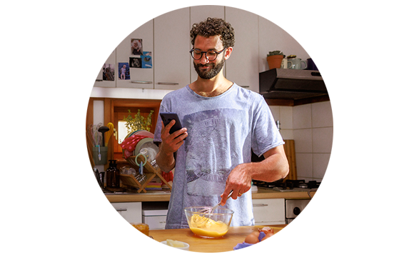 Persona cocinando con el móvil en la mano